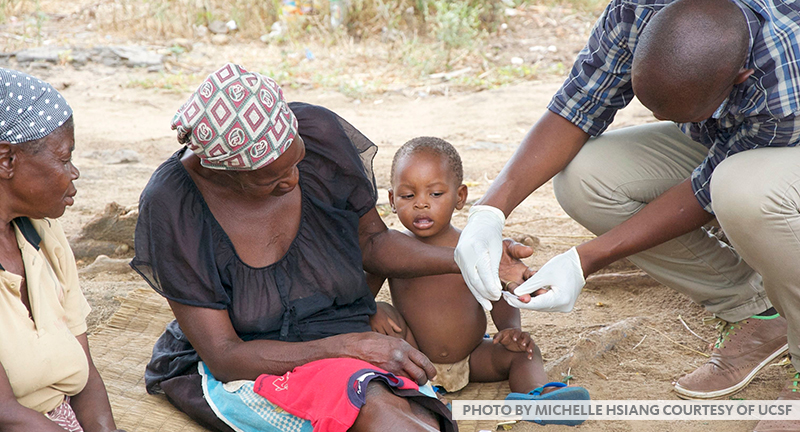 mother holding child who is being tested for malaria